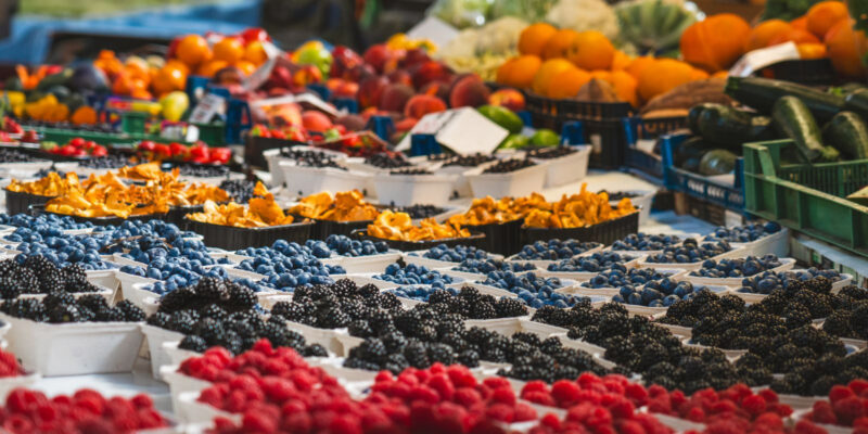 Colorful market stall featuring a variety of fresh berries and vegetables, perfect for a healthy diet.